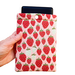 A hand holding a Kindle sleeve with snap to protect Kindle e-readers made with a pink back ground with red and white strawberries.